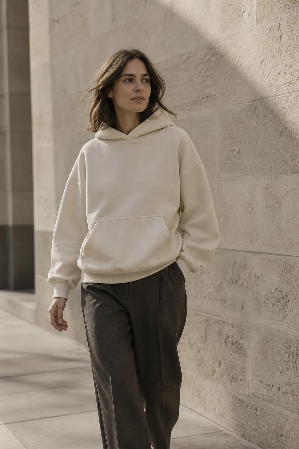 A model wearing a Bone hoodie in a warm Australian urban setting